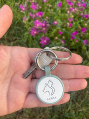 Porte-clé connecté AURIA Pets verte avec QR Code et NFC accroché à un trousseau de clés